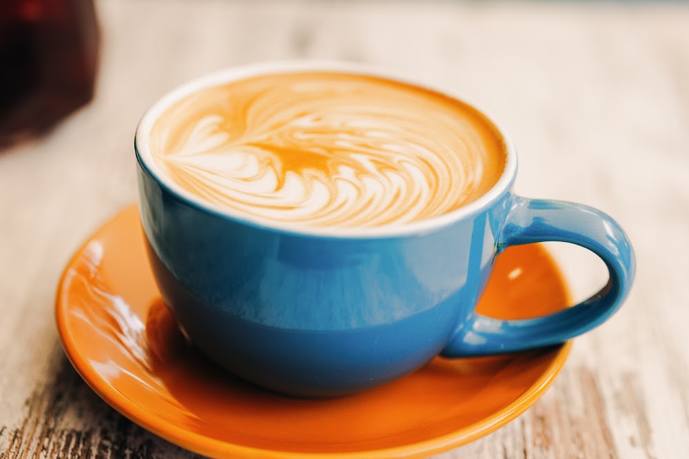 Latte art in a blue cup on an orange saucer at Myrtle Street Grind